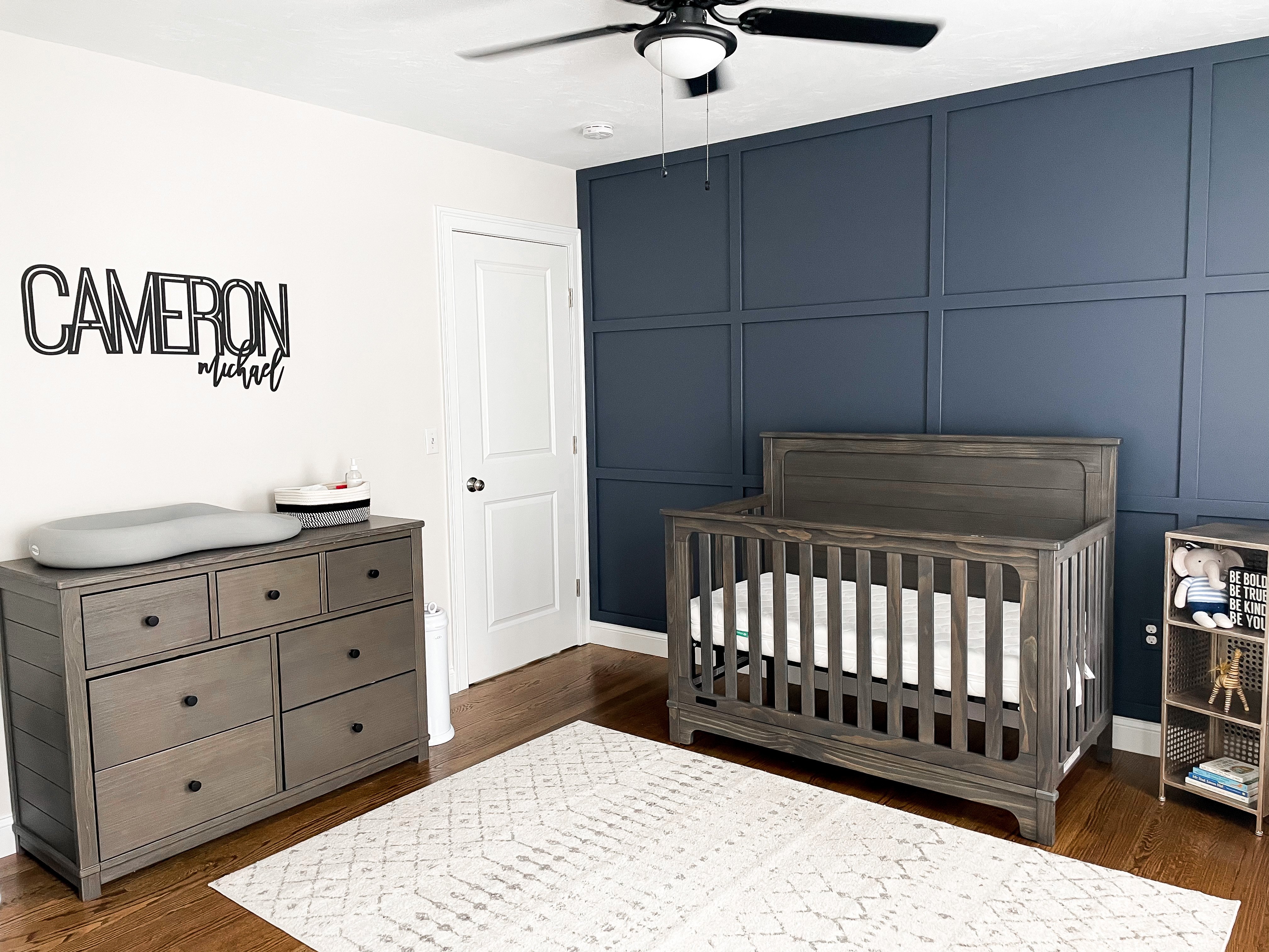 bedroom with wooden crib and blue painted wall